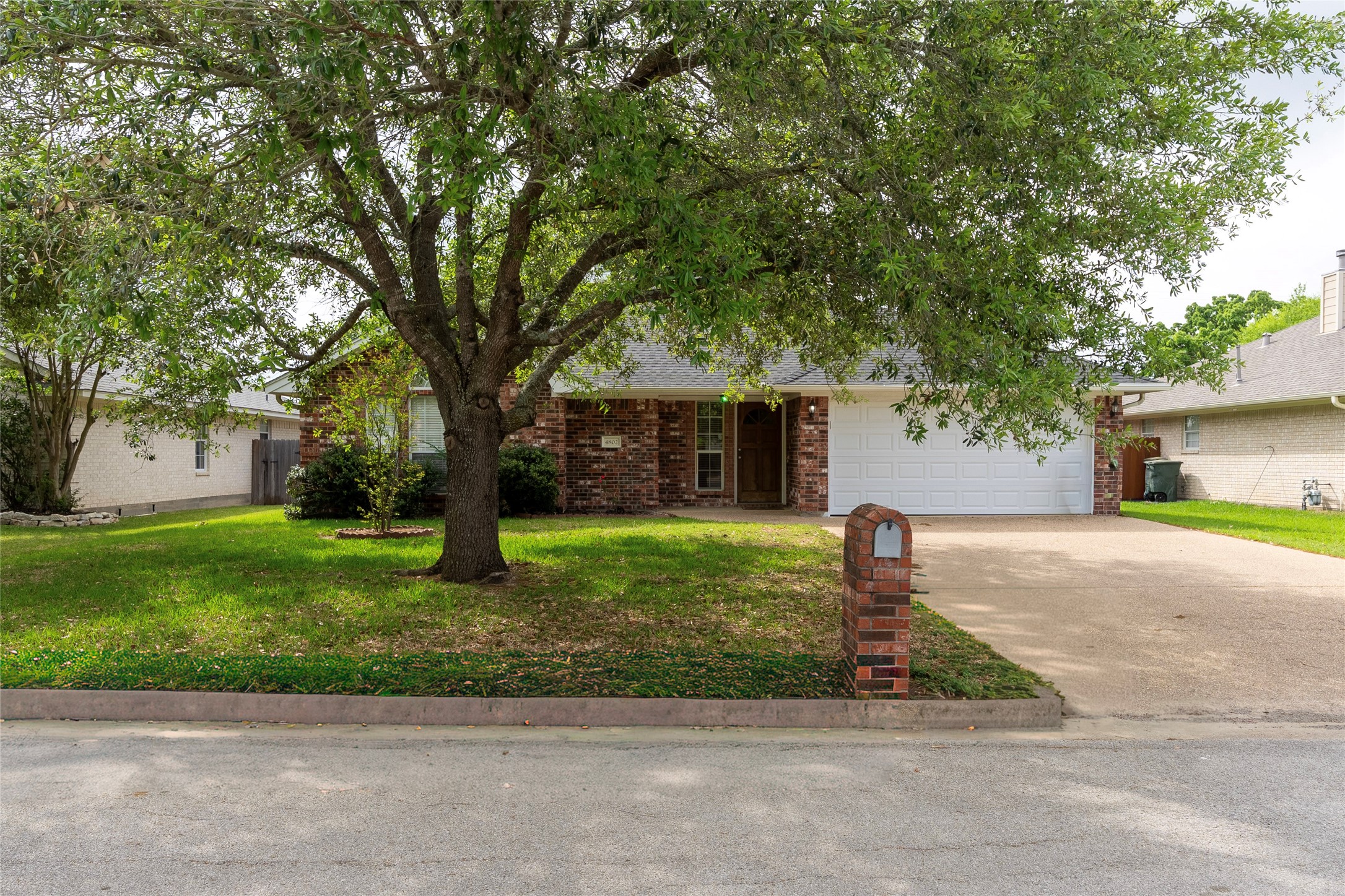 4802 Treadgold Lane Bryan, TX 77802 - Photo 5 of 27 a front view of a house with a yard and a garage