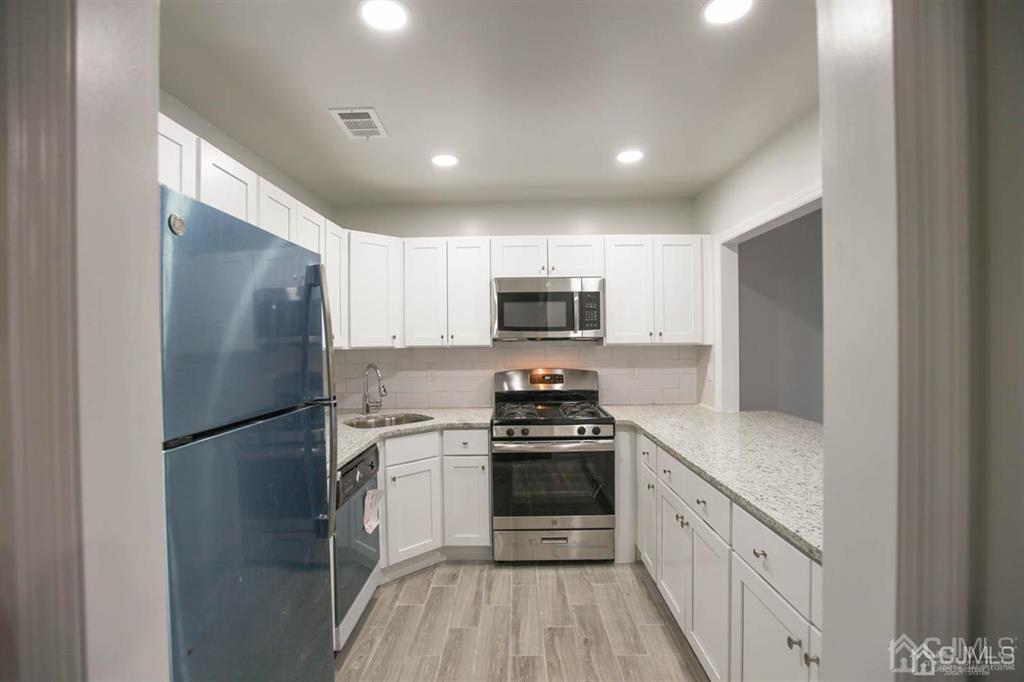 3203 Hana Road Edison, NJ 08817 - Photo 2 of 12 a kitchen with stainless steel appliances granite countertop a refrigerator a stove top oven a sink and dishwasher