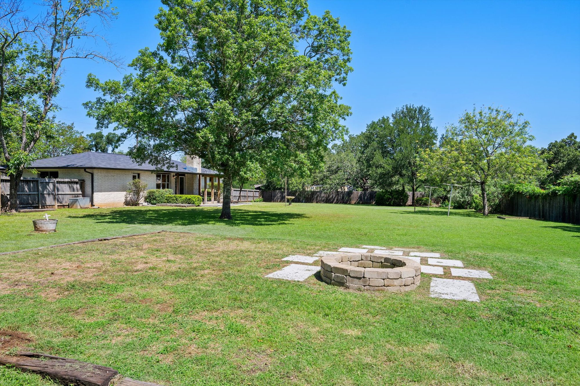 109 Woodland Road Georgetown, TX 78628 - Photo 37 of 40 An inviting fire pit takes center stage in this vast backyard, perfect for outdoor gatherings.