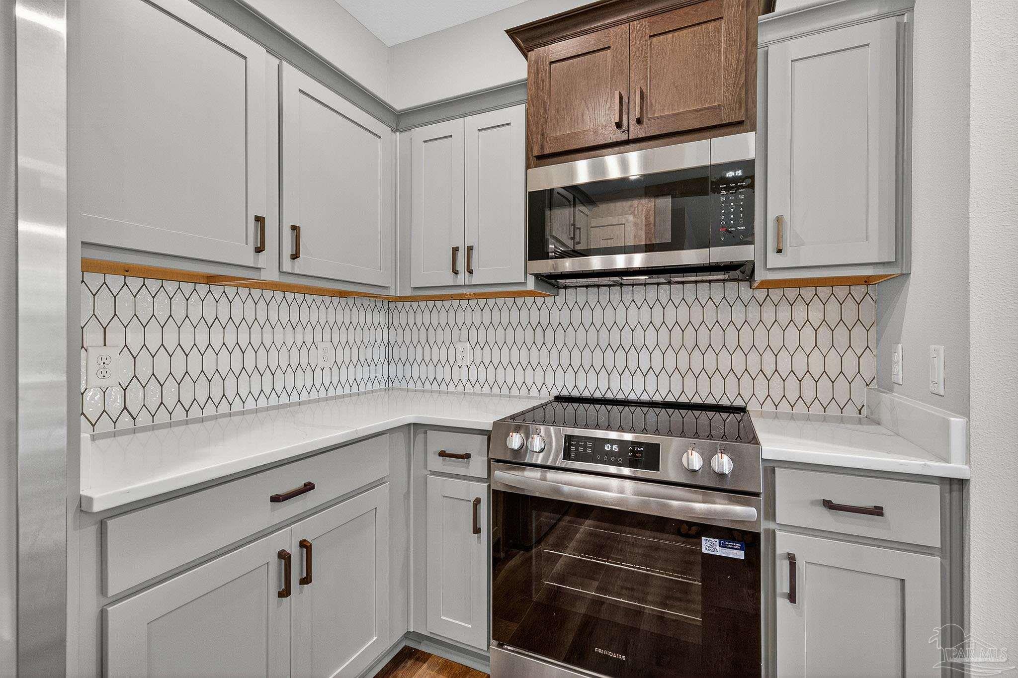 205 Webb Street Cantonment, FL 32533 - Photo 16 of 49 a kitchen with a stove and a microwave