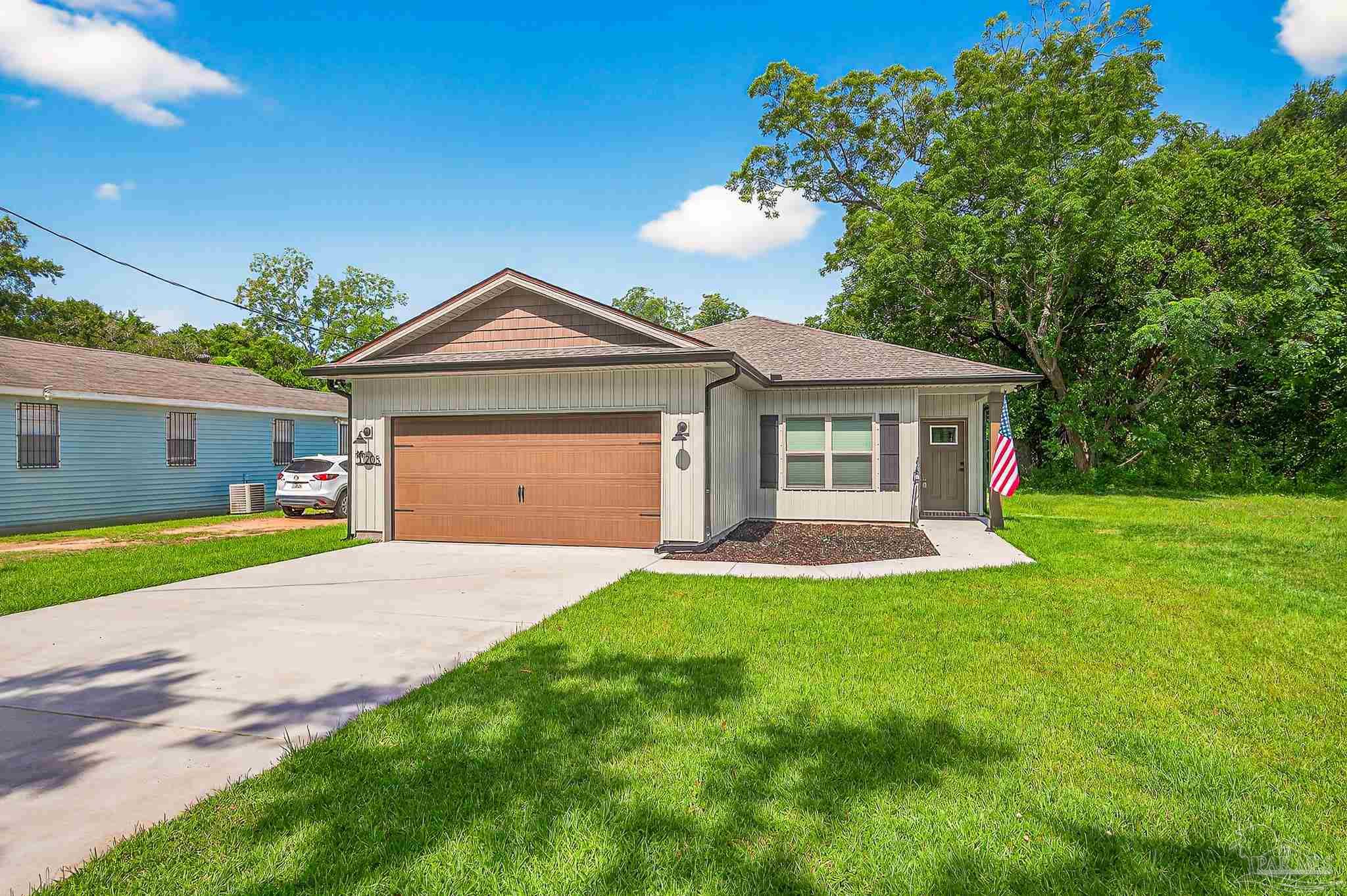 205 Webb Street Cantonment, FL 32533 - Photo 2 of 49 a front view of a house with a yard and garage
