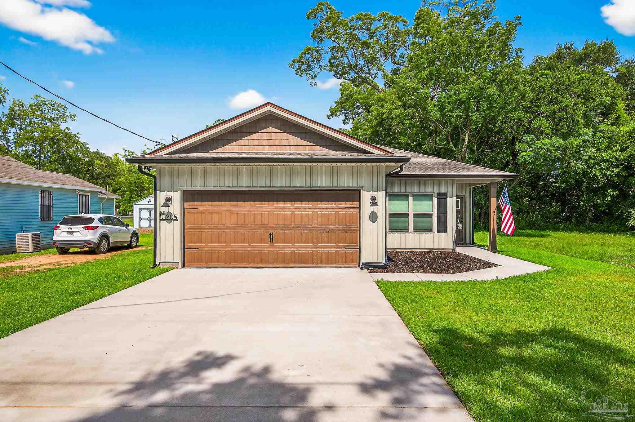 205 Webb Street Cantonment, FL 32533 - Photo 3 of 49 a front view of a house with a yard and garage