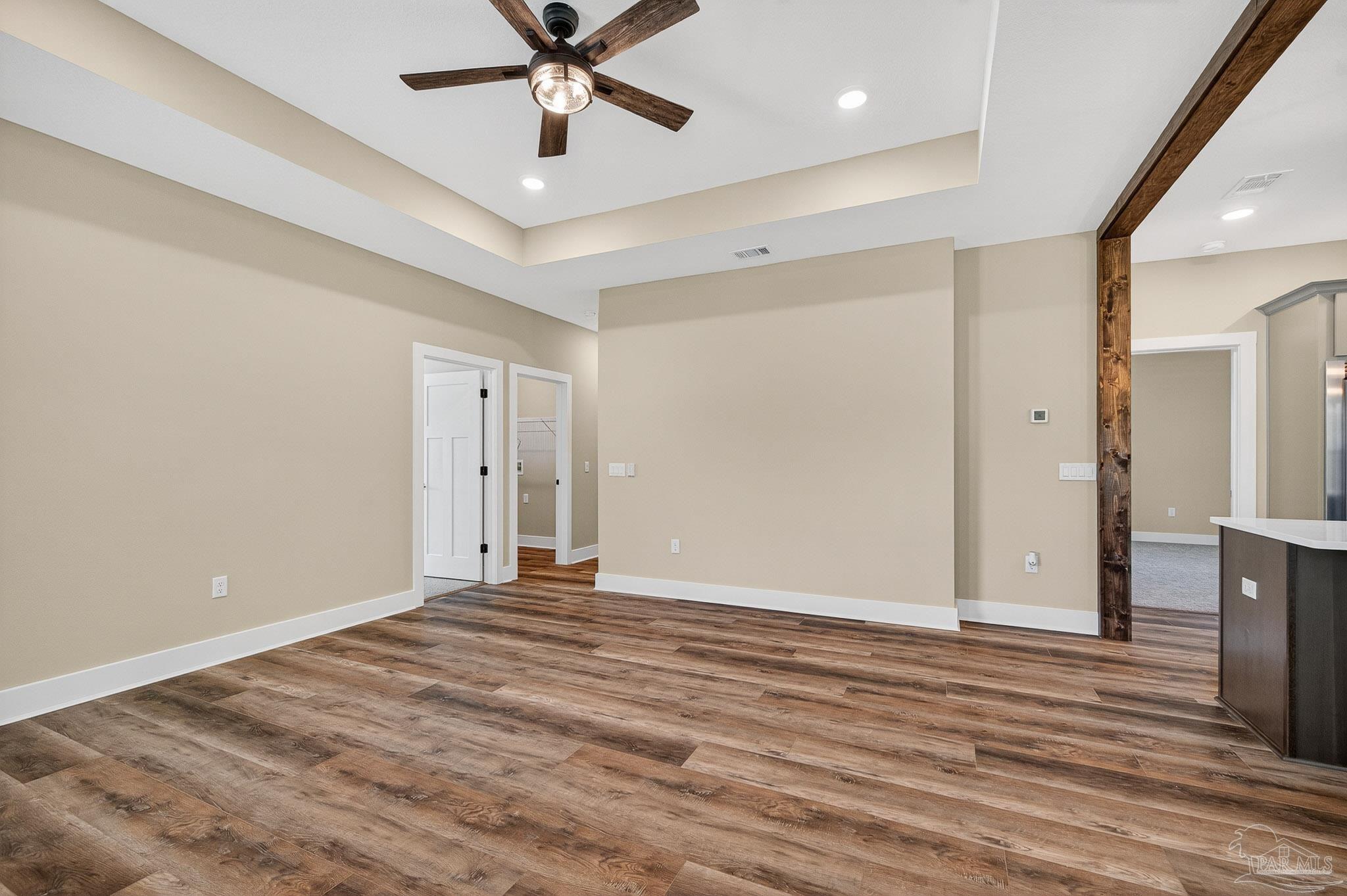 205 Webb Street Cantonment, FL 32533 - Photo 8 of 49 a view of an empty room with wooden floor and a ceiling fan