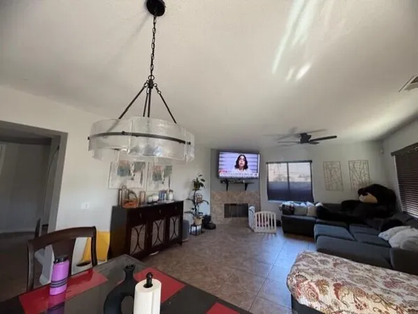 a living room with furniture a chandelier and a flat screen tv