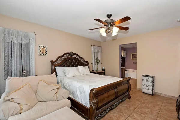 a bedroom with a bed and ceiling fan