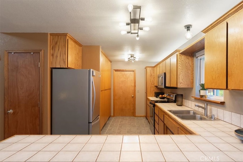 1533 West A Barr Road Mount Shasta, CA 96067 - Photo 11 of 38 a large kitchen with a stove a refrigerator and chandelier