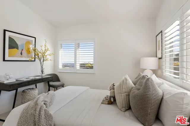 a view of a garden with plants and a bench
