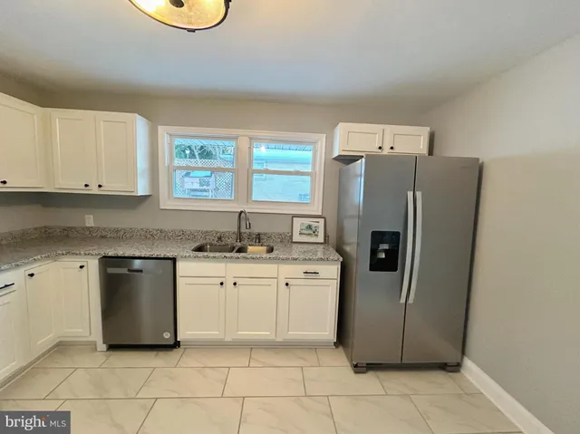 a kitchen with stainless steel appliances a refrigerator sink and cabinets