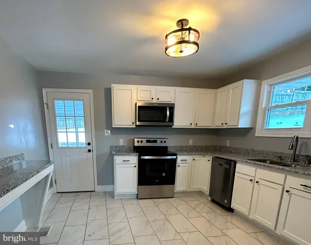 a kitchen with stainless steel appliances granite countertop a stove sink and cabinets