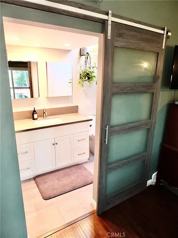 a bathroom with a granite countertop sink a toilet a mirror and shower