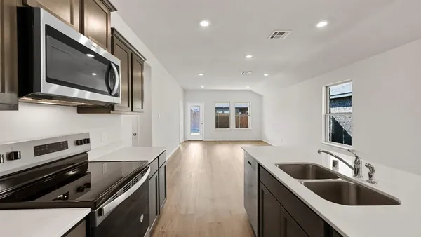 a kitchen with a sink stove and microwave