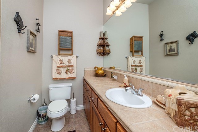 19286 Kanbridge Street Apple Valley, CA 92308 - Photo 15 of 37 a bathroom with a granite countertop toilet sink and mirror