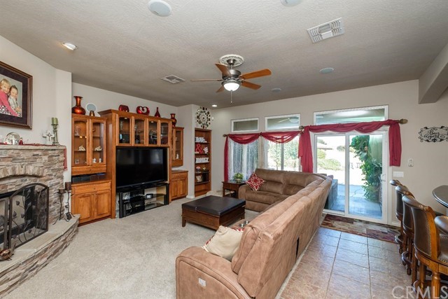19286 Kanbridge Street Apple Valley, CA 92308 - Photo 4 of 37 a living room with furniture a flat screen tv and a fireplace
