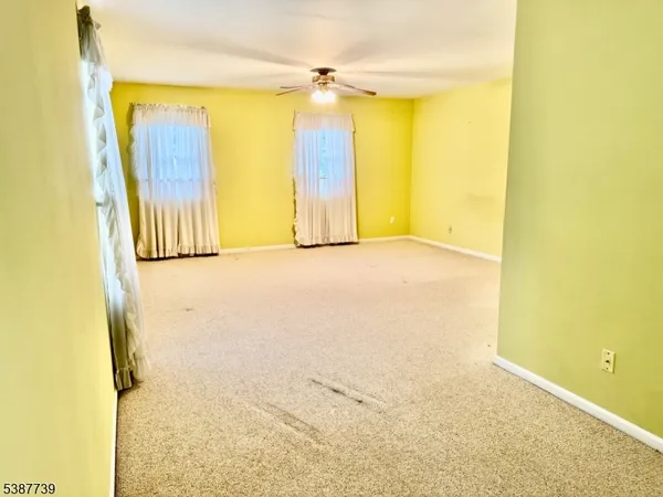 a view of a big room with wooden floor and windows