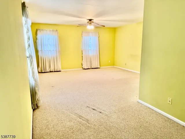 a view of a big room with wooden floor and windows