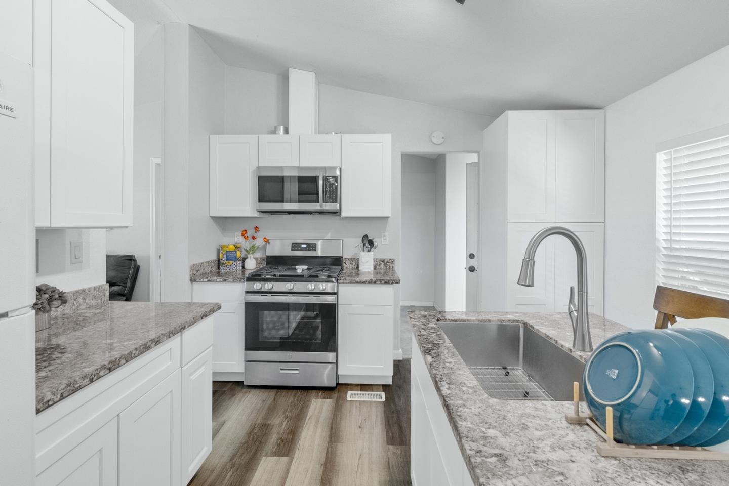 1900 Highway 1, Unit 62 Moss Landing, CA 95039 - Photo 9 of 21 a kitchen with granite countertop a stove a sink and a microwave