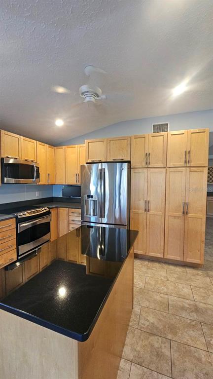 882 Lucas Lane Oldsmar, FL 34677 - Photo 13 of 27 a kitchen with stainless steel appliances a refrigerator and wooden cabinets