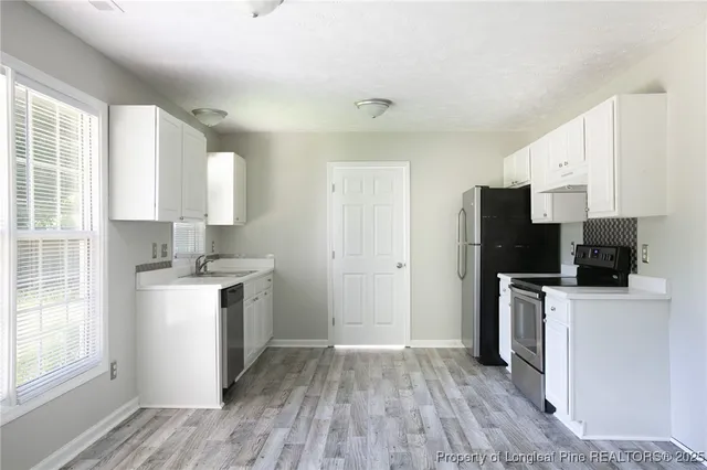 a kitchen with a stove a refrigerator and a sink