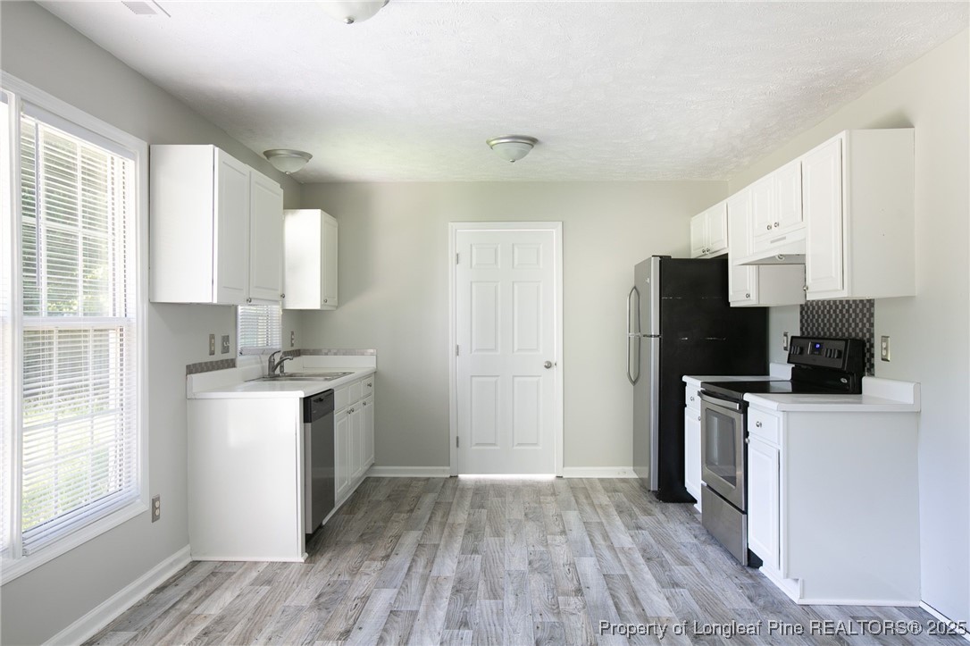 163 Independence Drive Raeford, NC 28376 - Photo 3 of 10 a kitchen with a stove a refrigerator and a sink