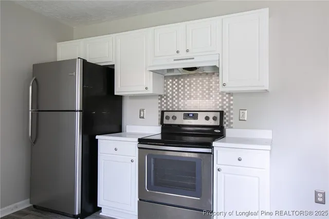 a kitchen with cabinets stainless steel appliances and a counter space