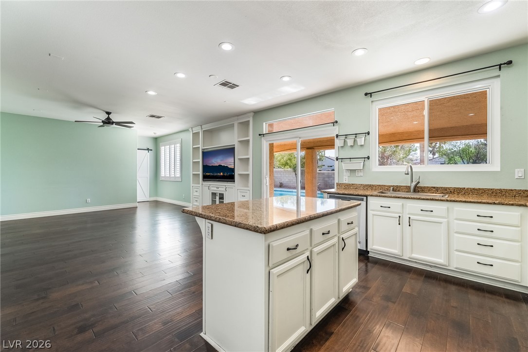 261 Timber Hollow Street Henderson, NV 89012 - Photo 18 of 51 A gourmet kitchen island anchors an open living space, offering generous storage and gleaming stone counters.