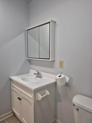 a bathroom with a sink toilet and mirror