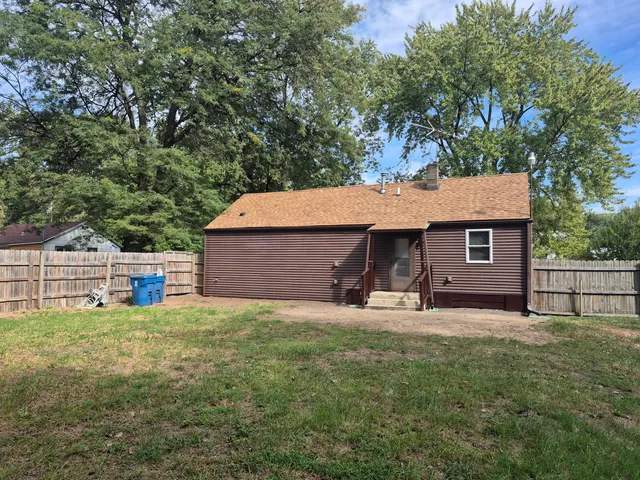 a view of a house with a yard and large tree