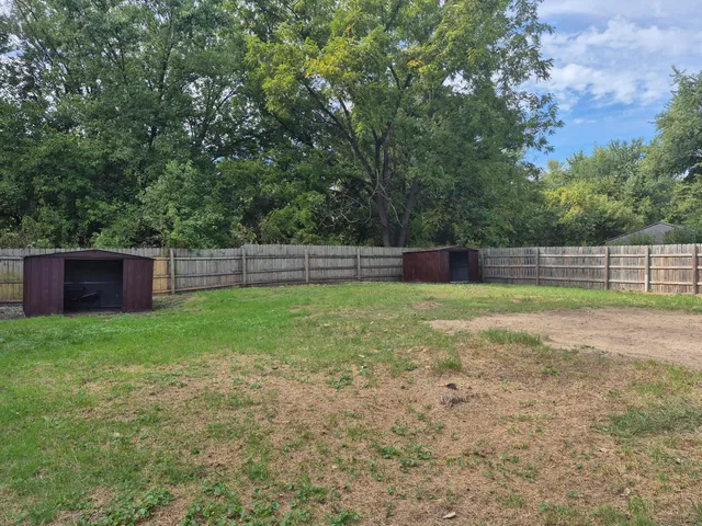 a view of yard with green space and wooden fence