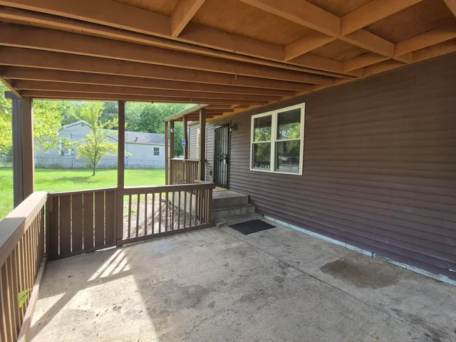 a view of a backyard with floor to ceiling window and wooden fence
