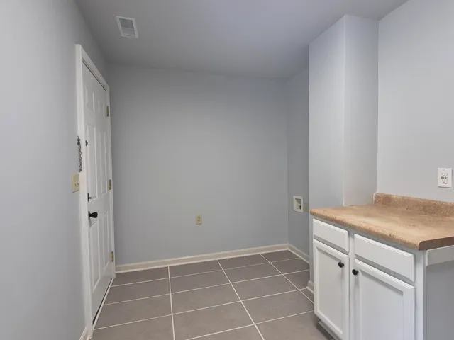 a room with washing machine and cabinets