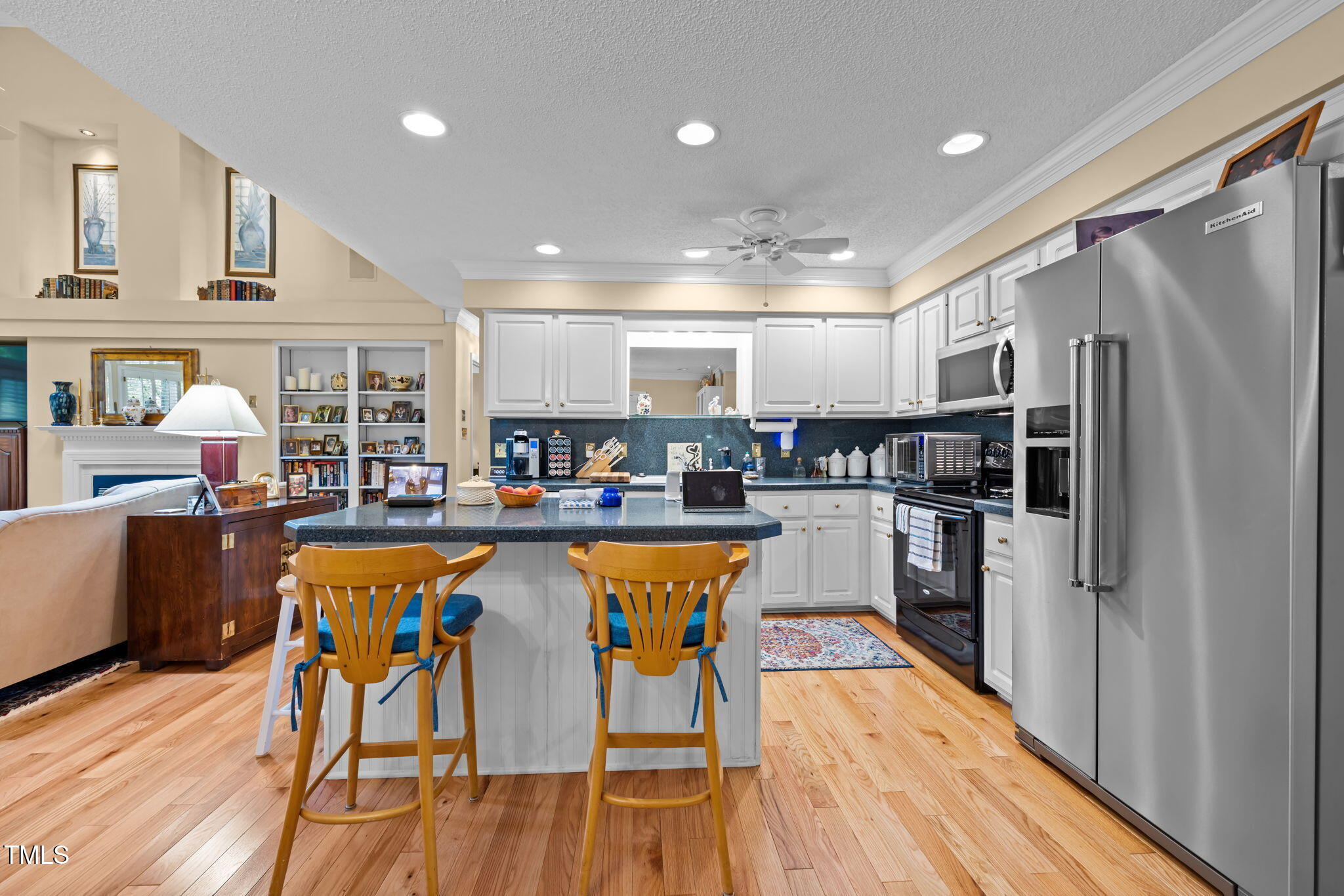 8516 Wheeling Drive Raleigh, NC 27615 - Photo 8 of 29 a kitchen with stainless steel appliances granite countertop a refrigerator a sink dishwasher a stove and white cabinets with wooden floor