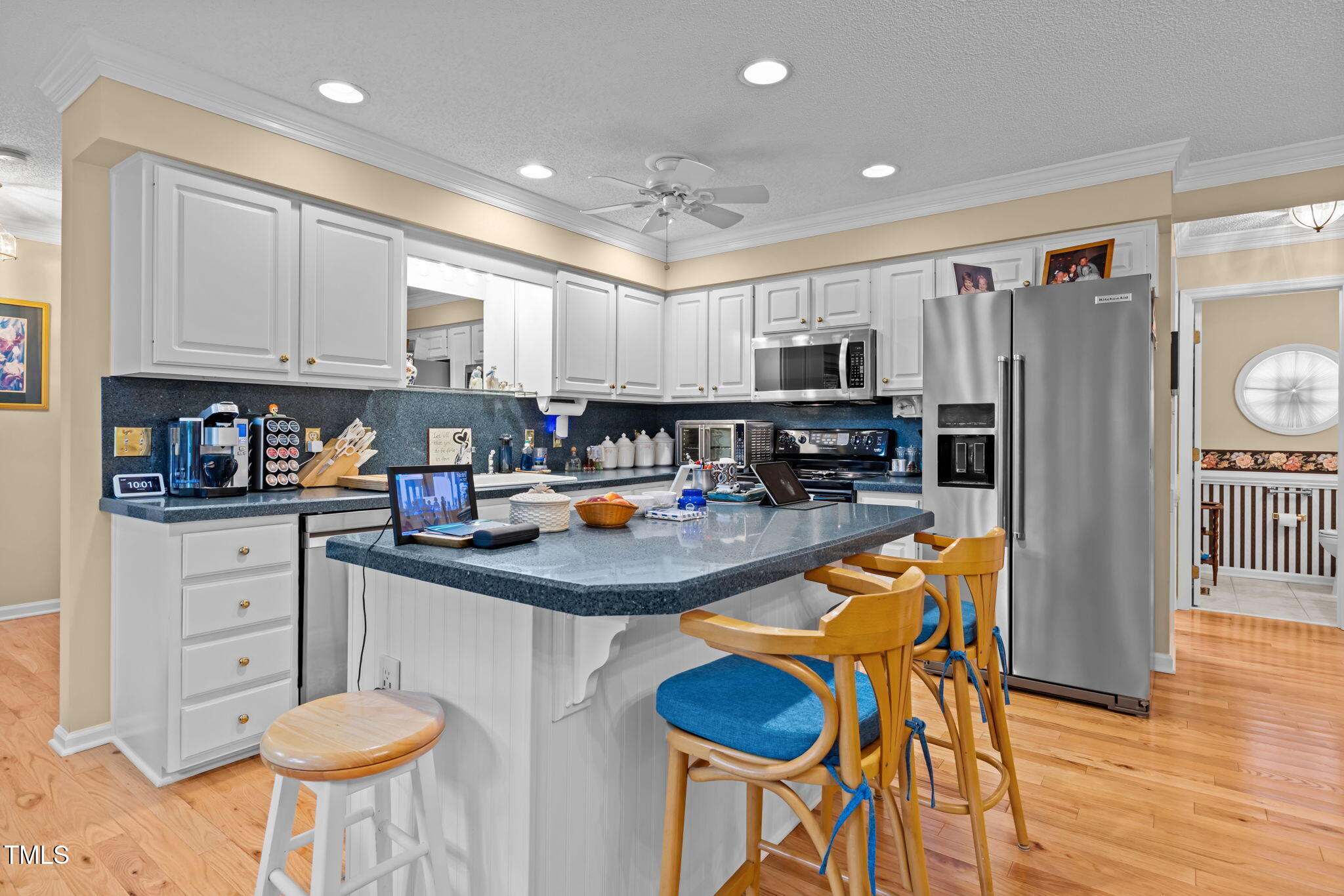 8516 Wheeling Drive Raleigh, NC 27615 - Photo 9 of 29 a kitchen with stainless steel appliances granite countertop a sink a stove a refrigerator cabinets and chairs