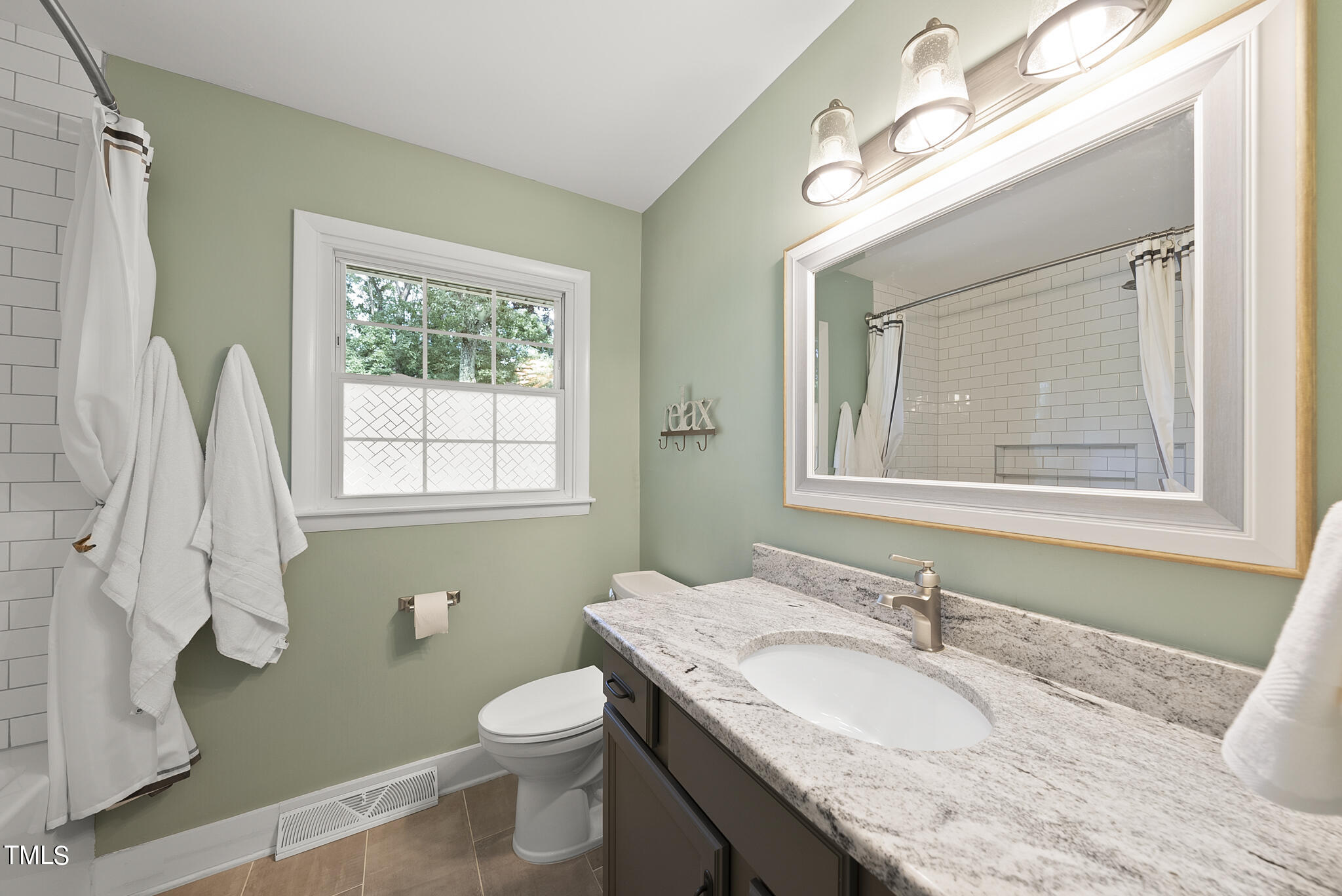 4900 Latimer Road Raleigh, NC 27609 - Photo 36 of 46 a bathroom with a granite countertop toilet a sink and a mirror