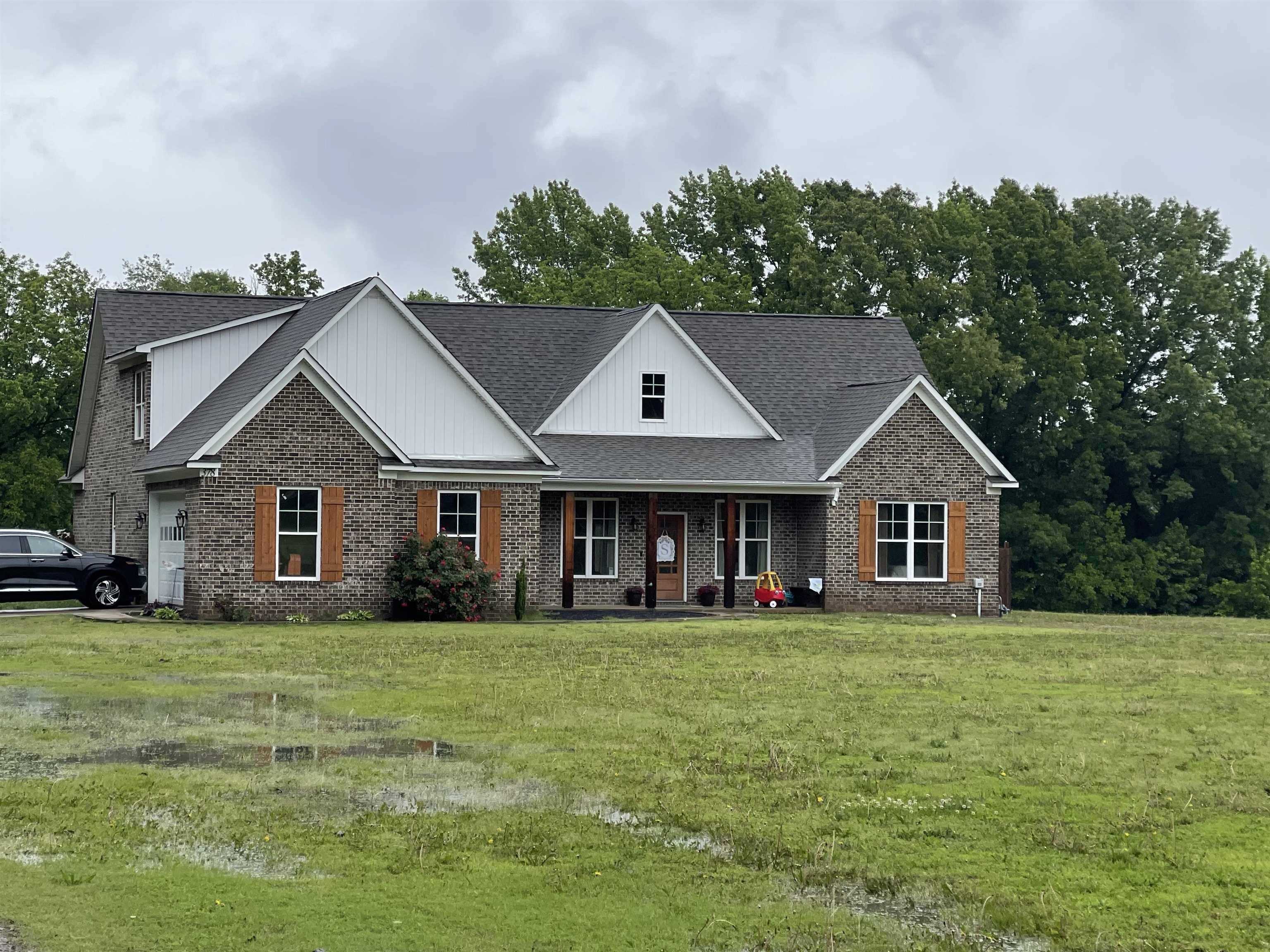 a view of a house with a big yard and large trees