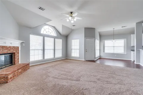 a view of an empty room with a fireplace and a window