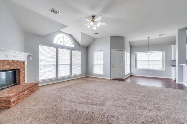 a view of an empty room with a fireplace and a window