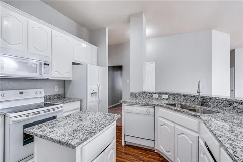 a kitchen with white cabinets and appliances