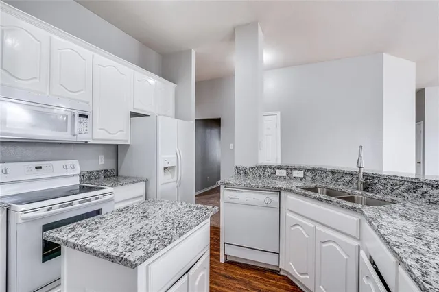a kitchen with white cabinets and appliances