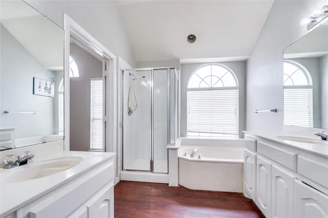 a bathroom with a granite countertop tub sink a window and mirror