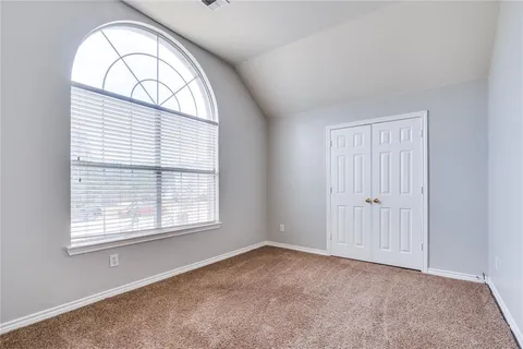 an empty room with windows and closet