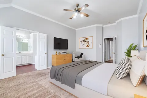 a bedroom with a bed flat screen tv and a couch