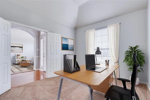 a living room with furniture a flat screen tv and a window