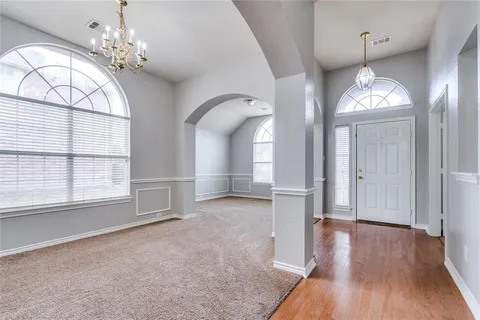 a view of a livingroom with wooden floor and windows