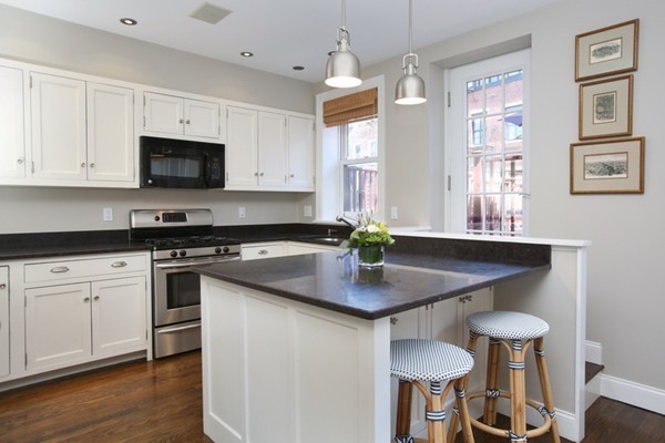 123 Charles Street, Unit 3 Boston, MA 02114 - Photo 5 of 18 a kitchen with stainless steel appliances a sink a stove a table and chairs