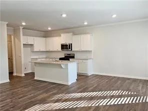 a kitchen with granite countertop white cabinets and white appliances