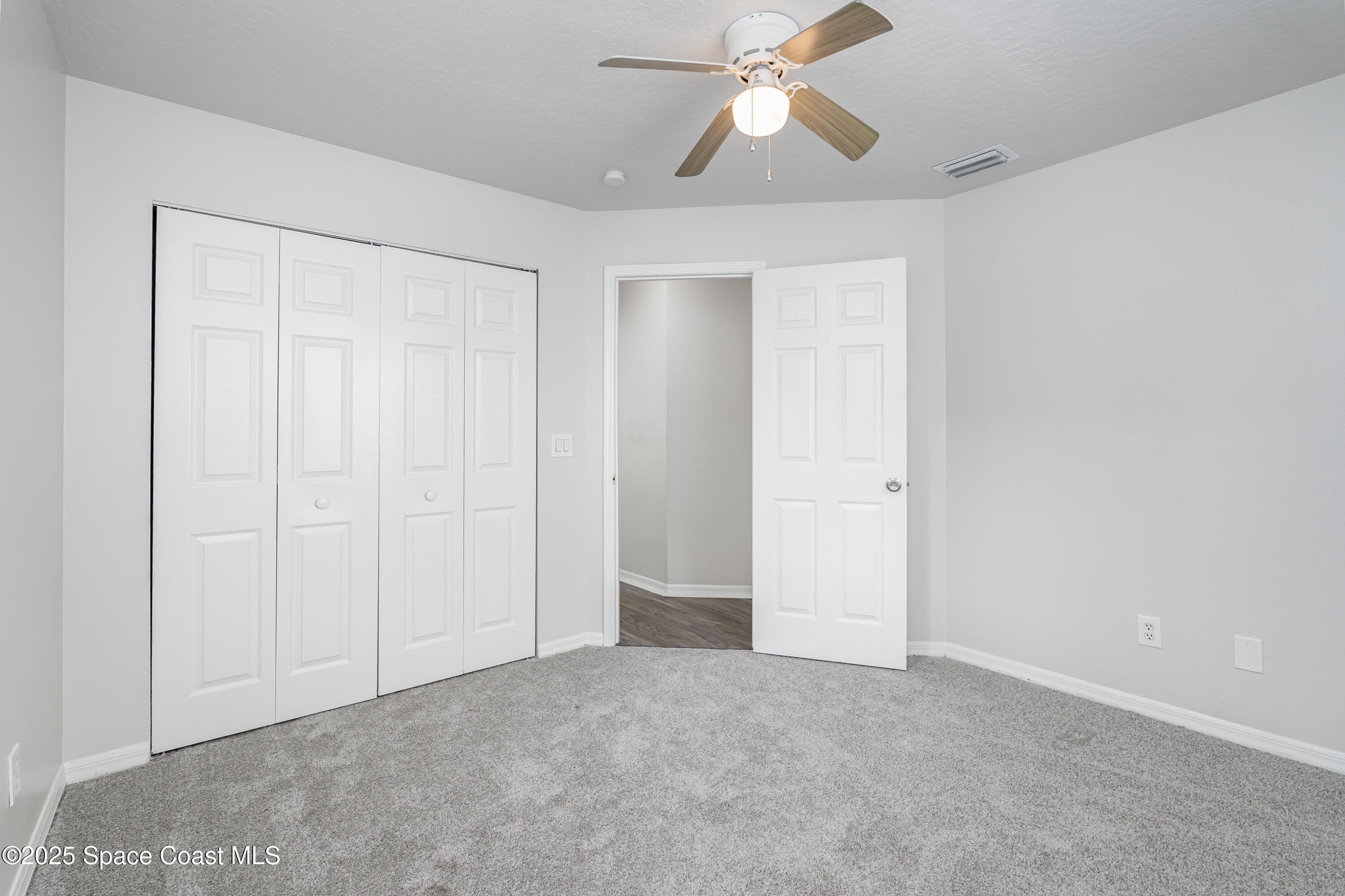 320 Myrtlewood Road Melbourne, FL 32940 - Photo 11 of 18 an empty room with closet and a chandelier fan