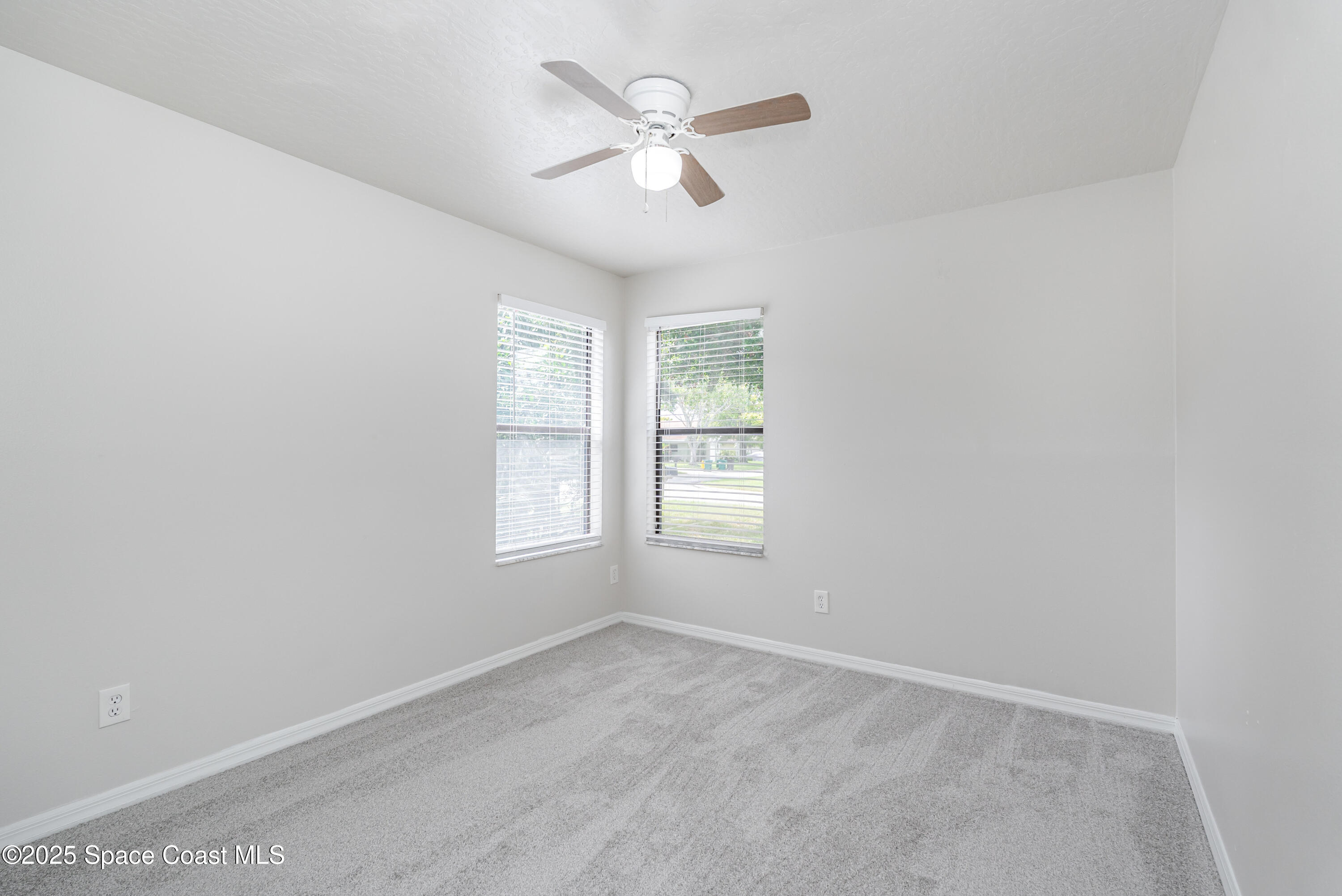 320 Myrtlewood Road Melbourne, FL 32940 - Photo 12 of 18 an empty room with ceiling fan and windows