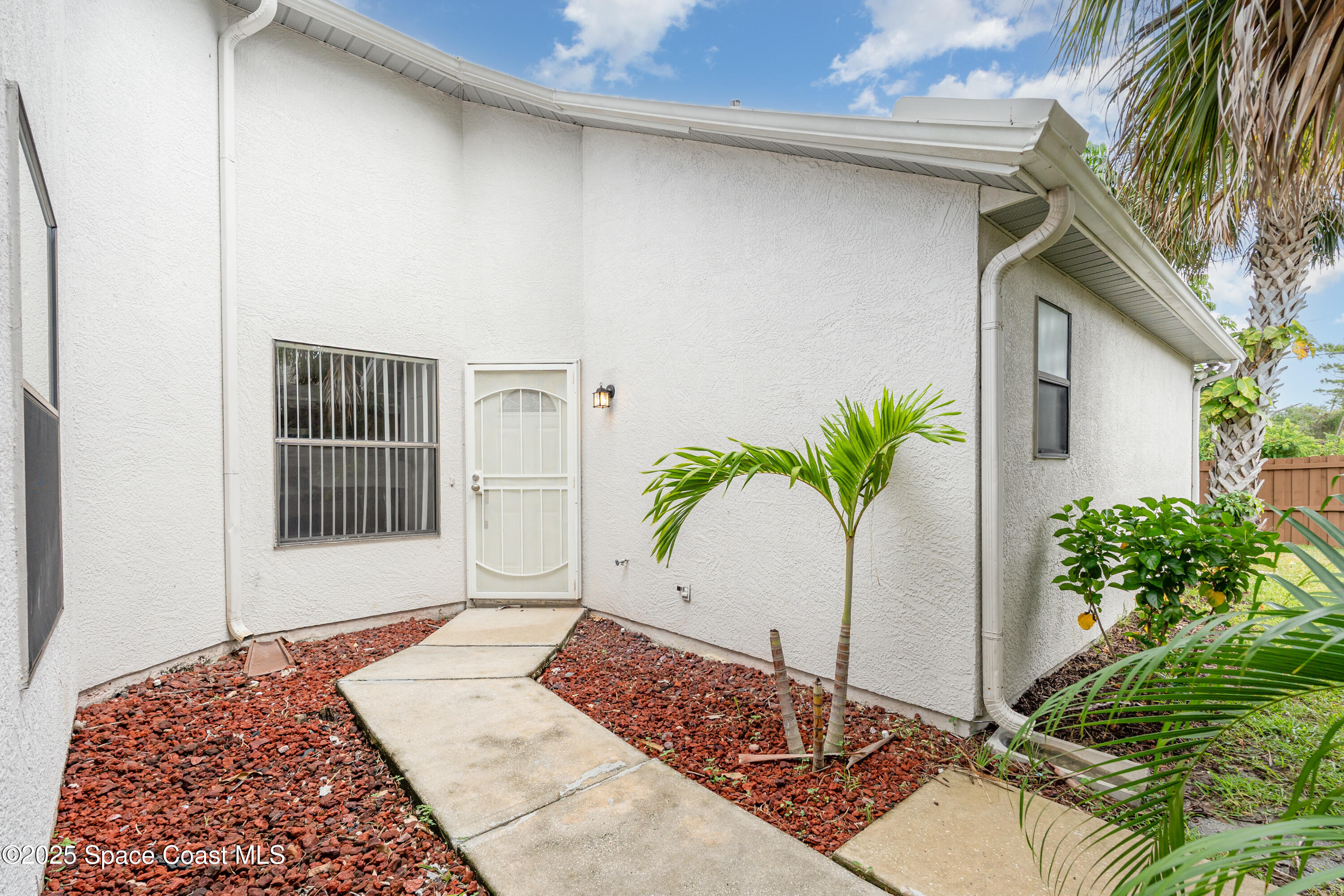 320 Myrtlewood Road Melbourne, FL 32940 - Photo 16 of 18 a white house with a blue and white door