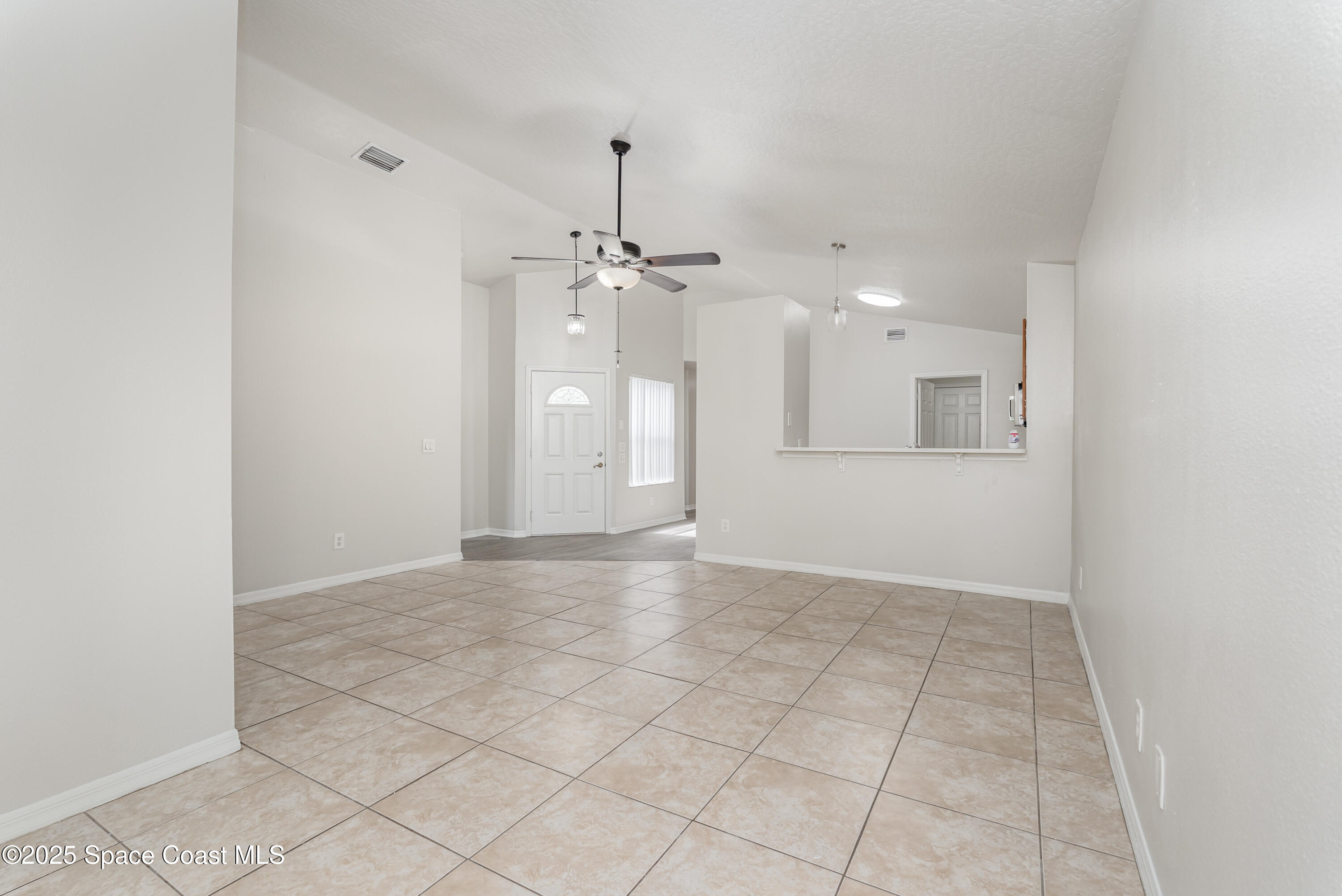 320 Myrtlewood Road Melbourne, FL 32940 - Photo 3 of 18 an empty room with kitchen view and natural light