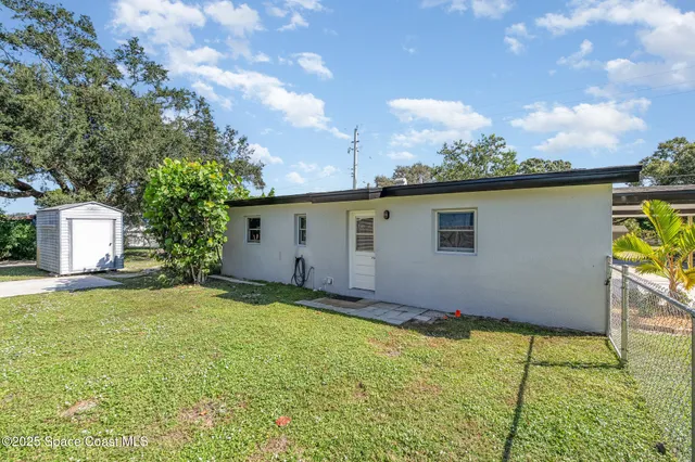a backyard of a house with table and chairs